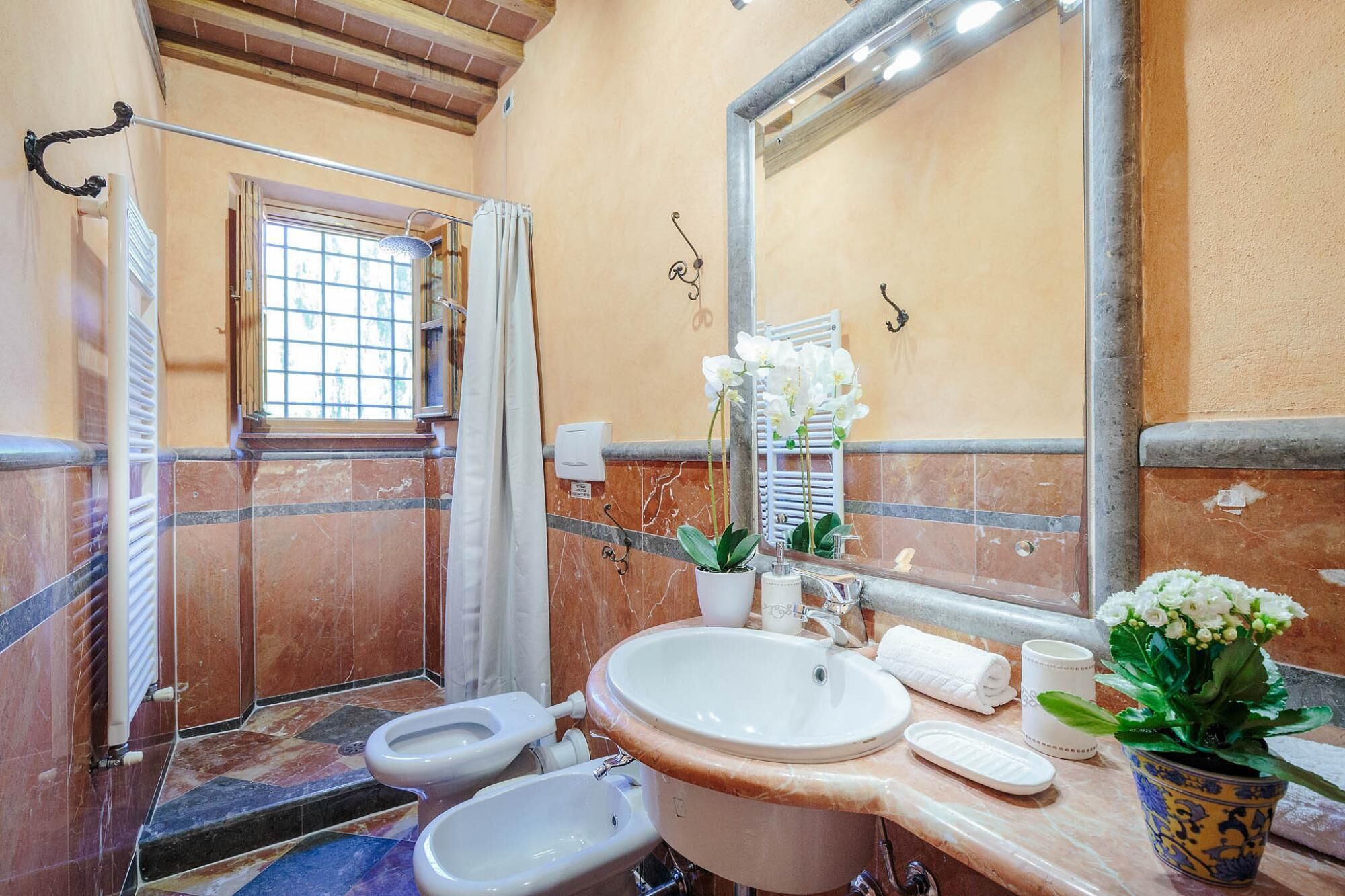 Ein Badezimmer mit Dusche, Toilette, Waschbecken und Spiegel.