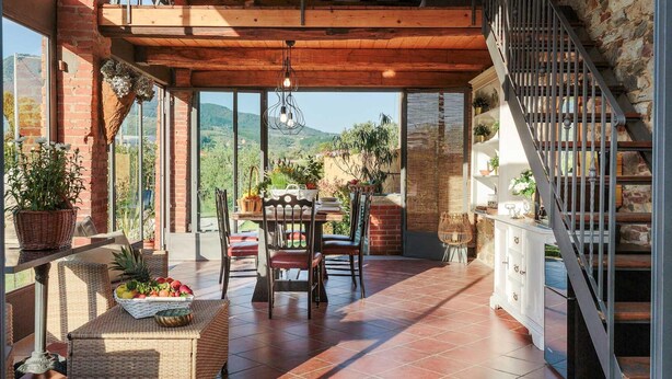 A spacious patio with a dining area, a staircase, and a view of the countryside. - Villa Ricordi in Marlia (Capannori)