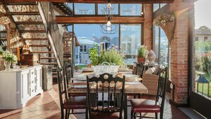 A dining area with a wooden ceiling, large windows, and a view of the city. - Villa Ricordi in Marlia (Capannori)