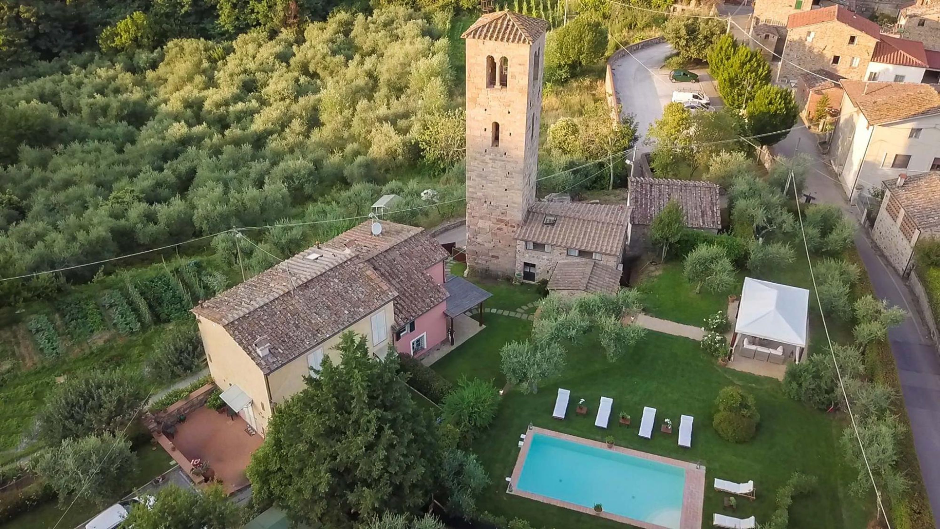 A villa with a swimming pool, a tower, and a garden.