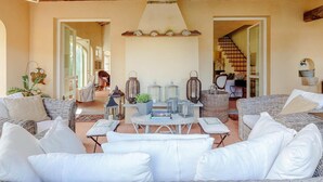 A cozy living room with wicker furniture, a central table, and a ceiling fan. - Villa Label in Camaiore (Camaiore)