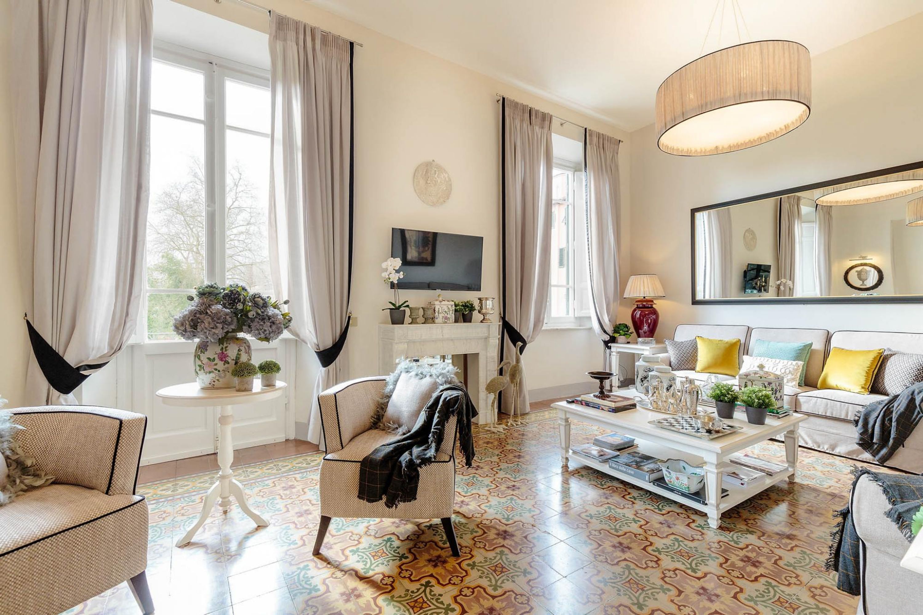 A living room with a sofa, armchairs, a coffee table, and a fireplace.