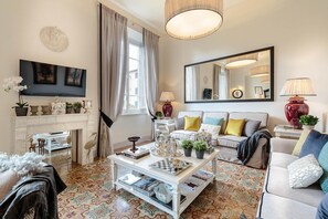 Una sala de estar con chimenea, un sofá, una mesa de centro y una televisión.