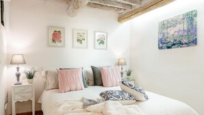 A bedroom with a bed, bedside tables, and wall art.