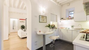 A modern kitchen with white cabinetry, a central island, and a bar stool.
