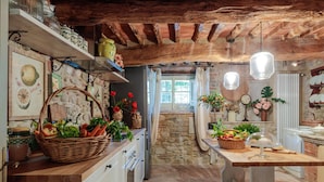 A rustic kitchen with stone walls, wooden beams, and a stone staircase leading to a window. - Villa Hugo in Lucca With 5 Bedrooms and 6 Bathrooms (Lucca)