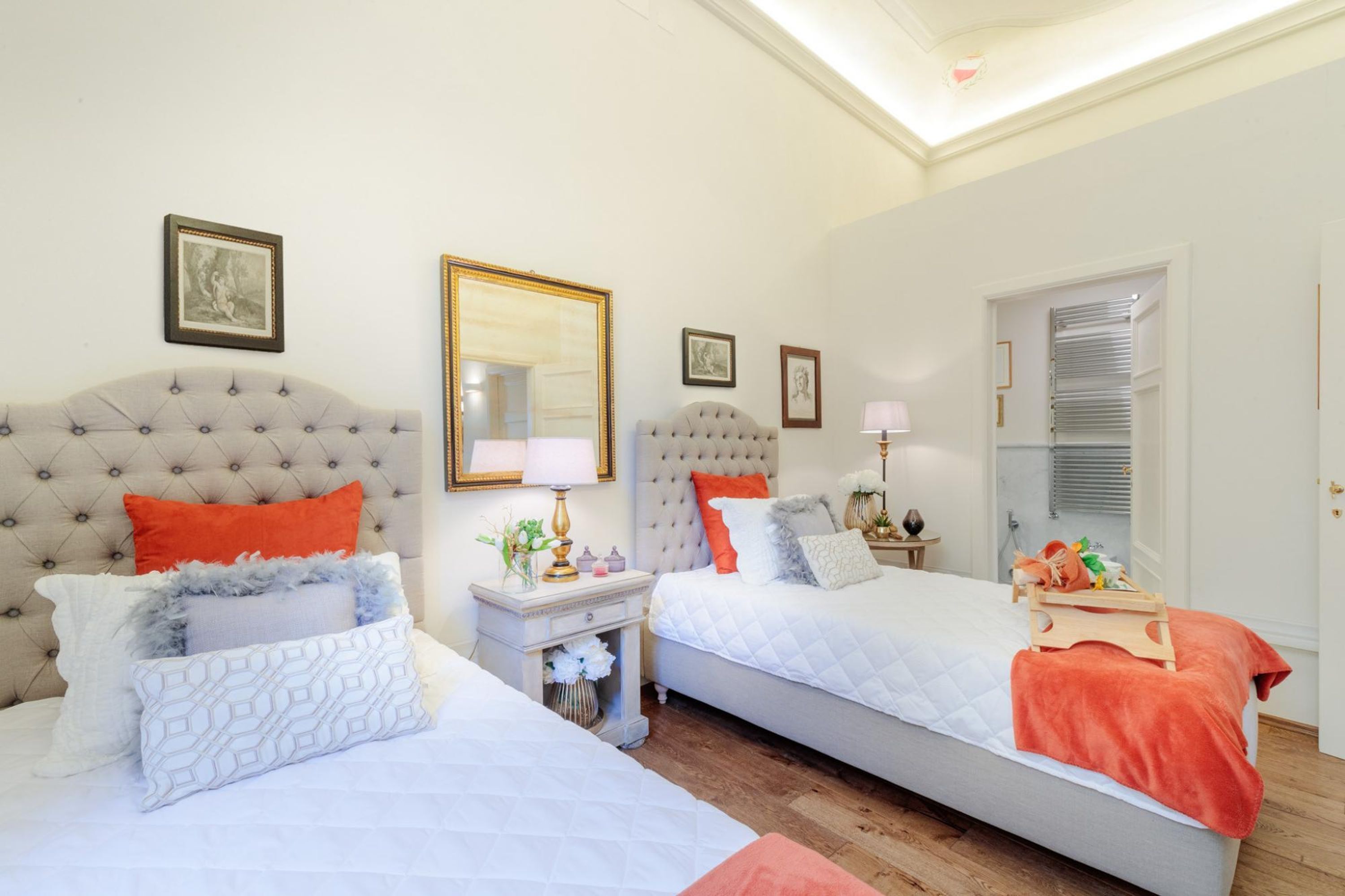 A hotel room with two beds, a large mirror, and a wardrobe.