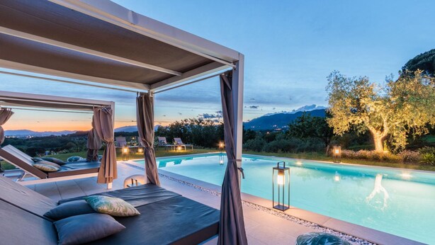 A poolside lounge area with reclining chairs and a covered seating area, overlooking a swimming pool and a mountainous landscape. - Villa Duemani - Pickleball Retreat (Capannori)