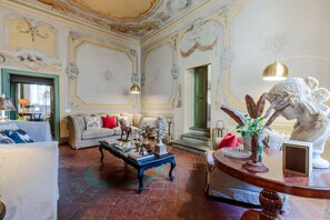 A spacious living room with a sofa, coffee table, and decorative items. - Casa Penelope in Lucca (Lucca)