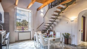 A modern kitchen with a dining area, a staircase, and a view of the outside. - Appartamento Caruso in Sorrento (Sorrento)