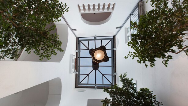 A courtyard with a central lantern, white walls, and trees. - Maison Palazzo Correale (Sorrento)