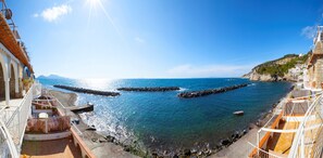 A coastal view with clear blue sea, rocky shore, and buildings with balconies. - Villa del Sole in Massa Lubrense (Massa Lubrense)