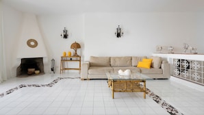 A living room with a sofa, a glass coffee table, a fireplace, and wall sconces. - Villa del Sole in Massa Lubrense (Massa Lubrense)