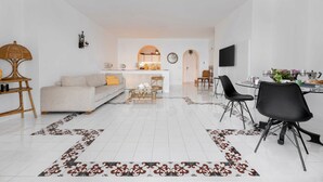 A modern living room with a sofa, coffee table, and dining area with chairs. - Villa del Sole in Massa Lubrense (Massa Lubrense)