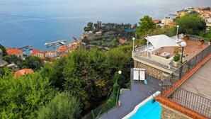 Une piscine sur le toit offrant une vue sur la mer et les bâtiments environnants.