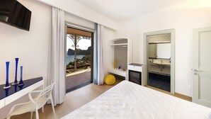 Ein modernes Schlafzimmer mit Bett, Schreibtisch und Meerblick.