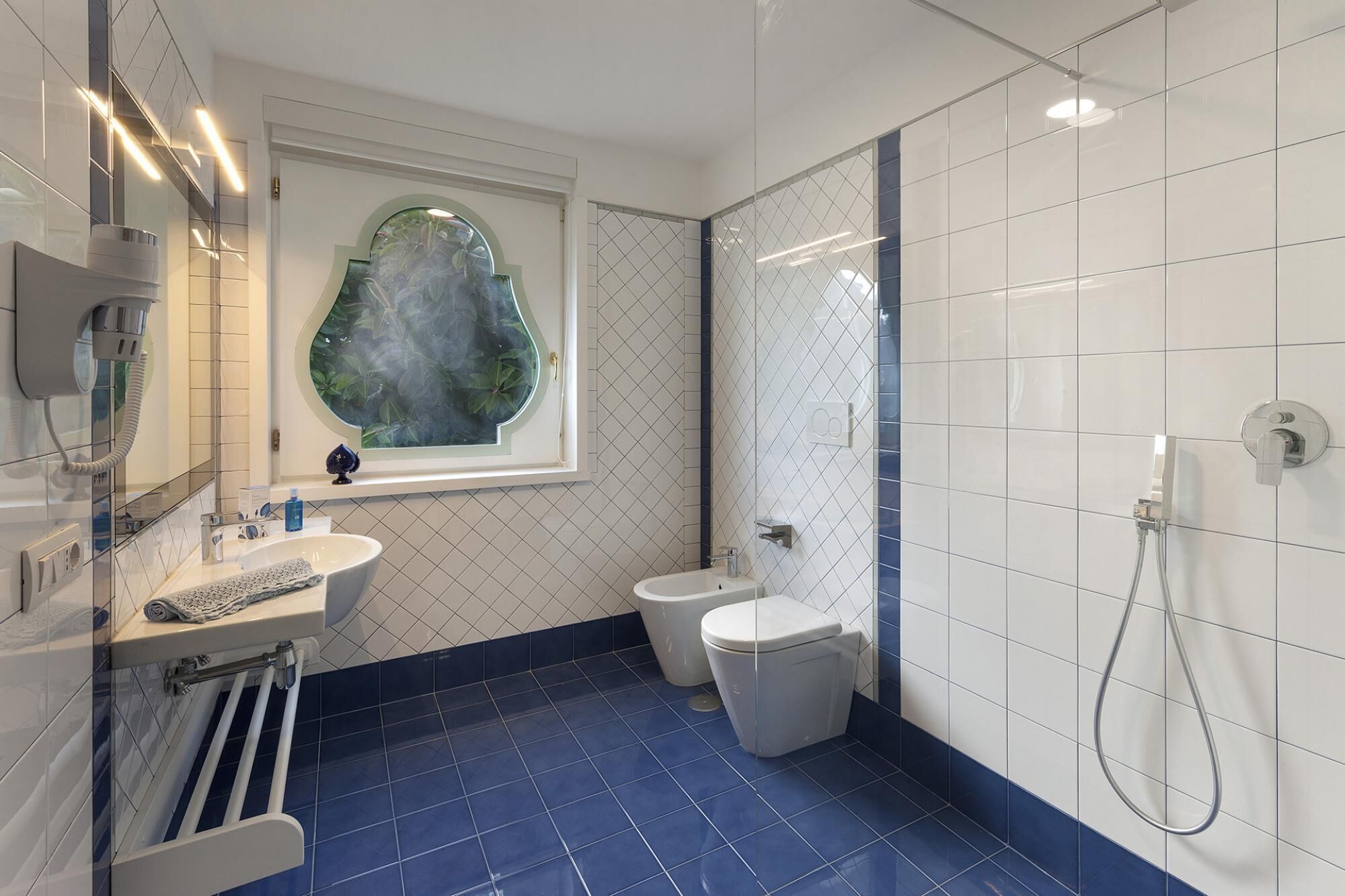 A bathroom with a white sink, a toilet, and a shower.