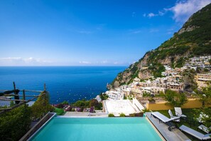 A pool with a view of the sea and a hillside town. - Villa Mimosa in Positano (Positano)