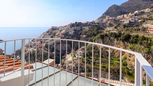 Un pueblo costero con edificios escalonados y una vista despejada del mar.