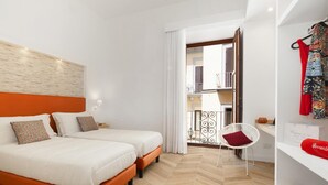 A hotel room with two beds, a wardrobe, a chair, and a view of the outside balcony. - Casa 80 in Sorrento With 3 Bedrooms and 2 Bathrooms (Sorrento)