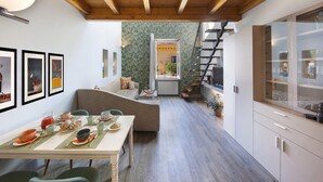 Eine moderne Küche mit Essbereich, Holzbalken an der Decke und Blick auf den Balkon.