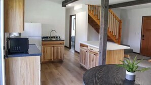 A modern kitchen with wooden cabinets, a built-in microwave, and a central island.