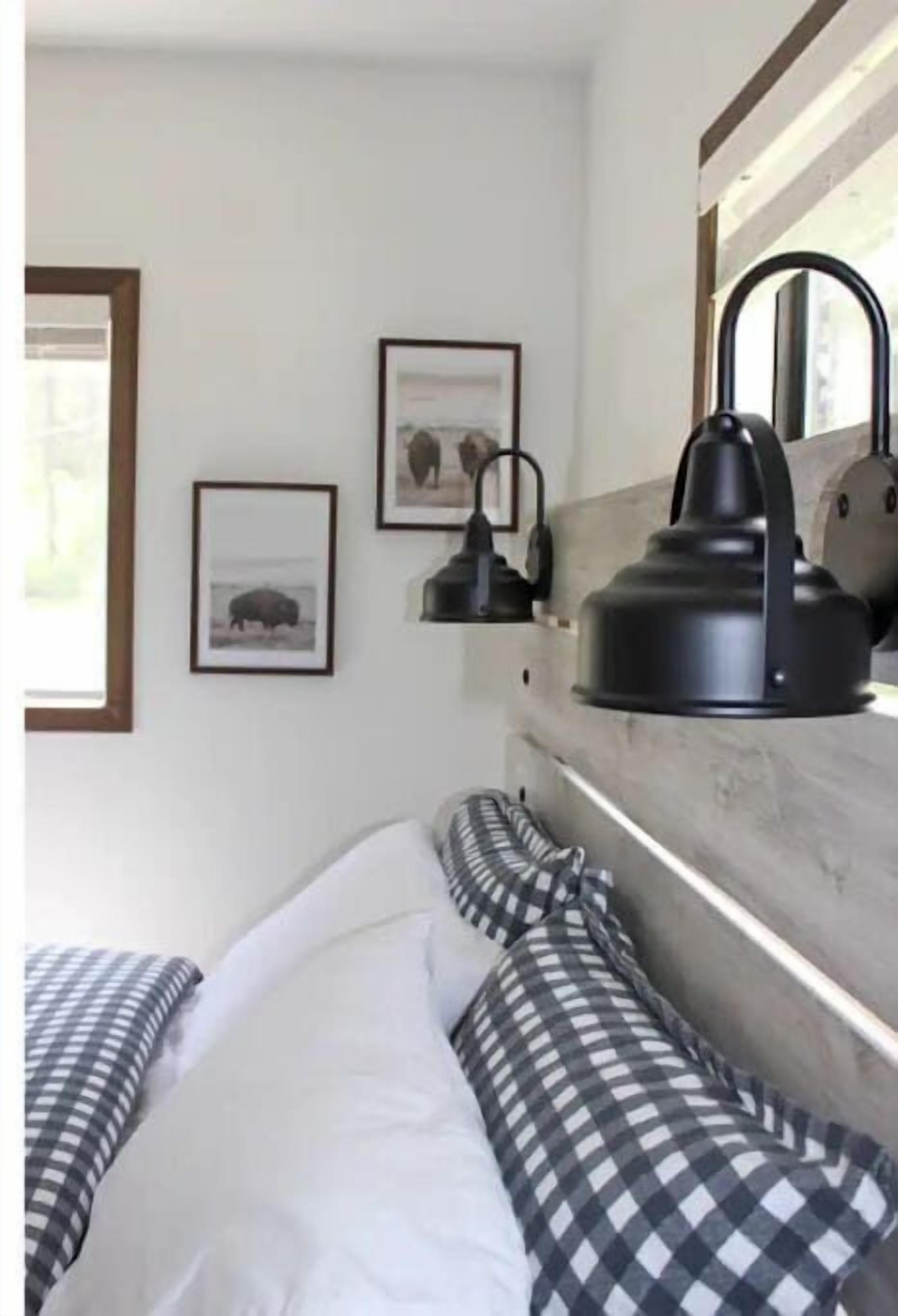 A bedroom with a bed, a kettle, and framed pictures on the wall.