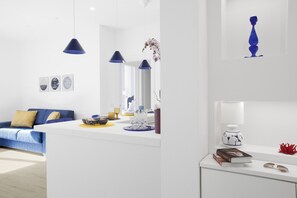 A modern living room with a blue sofa, white coffee table, and blue pendant lights. - Sara Home 1 in Sorrento (Sorrento)