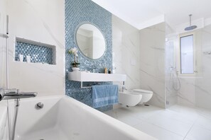 A modern bathroom with a bathtub, a toilet, and a shower area. - Sara Home 2 in Sorrento (Sorrento)