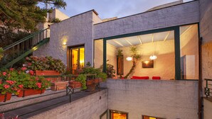 A modern building with a stone facade, a staircase, and a balcony with potted plants. - Villa Elia in Massa Lubrense (Massa Lubrense)