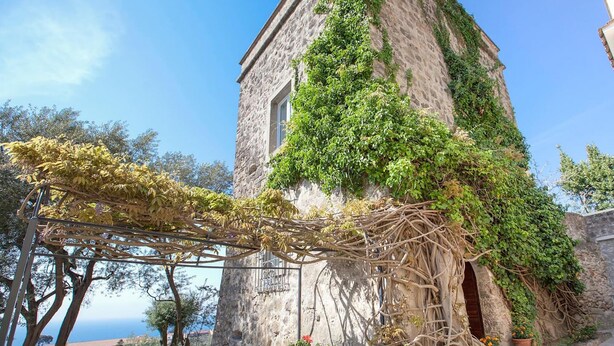 A stone building with a vine-covered exterior and a pergola with yellow leaves. - Villa Stella in Massa Lubrense (Massa Lubrense)