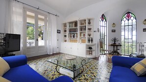 A living room with a blue sofa, a glass coffee table, a bookshelf, and a TV. - Villa Angelo in Sant Agnello (Sant'Agnello)