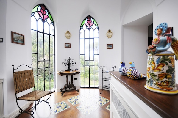 Experience a serene ambiance in this inviting room, featuring a traditional chair, ornate table, and decorative vases.