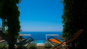 Two lounge chairs facing a pool with a clear view of the sea. - Villa Raffaella in Sant Agata sui Due Golfi (Massa Lubrense)
