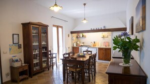 A spacious kitchen with a dining area, wooden cabinets, and a tiled floor. - Villa Raffaella in Sant Agata sui Due Golfi (Massa Lubrense)