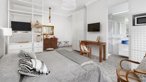 A modern bedroom with a bed, a desk, a chair, a TV, and a wardrobe. - Appartamento Sorrento Suite de Charme 1 (Sorrento)