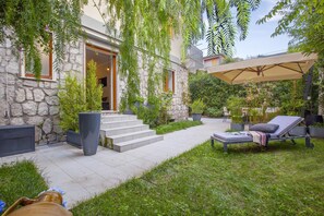 A stone building with a patio, outdoor seating, and a covered area. - Appartamento Sorrento Suite de Charme 1 (Sorrento)