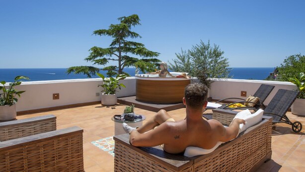 A man relaxing on a wicker lounge chair with a view of the sea. - Villa Isabel in Praiano (Praiano)