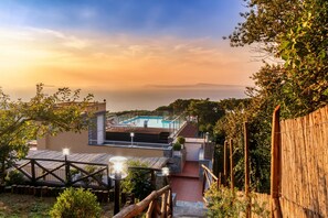 Une villa moderne dotée d’une piscine, d’une terrasse en bois et offrant une vue sur l’océan.