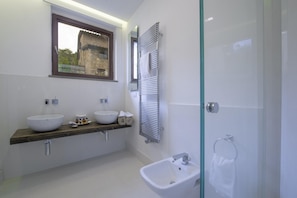 A modern bathroom with two sinks, a bidet, and a glass shower enclosure. - Ville Il Paradiso - Villa Bacci (Greve in Chianti)