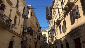 Una calle estrecha bordeada de edificios históricos, algunos con balcones y unidades de aire acondicionado.