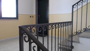 A staircase with a black wrought iron railing leading to a door. - Casa Ilaria 2 Bedrooms Apartment in Alghero (Alghero)