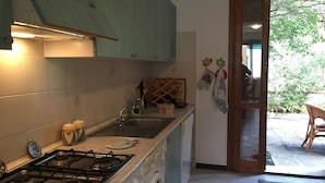 A kitchen with a gas stove, a washing machine, and a sink. - Casa Marta 4 Bedrooms Apartment in Stintino (Stintino)