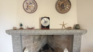 A fireplace with a mantel displaying various decorative items. - Casa Marta 4 Bedrooms Apartment in Stintino (Stintino)