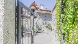 A stone building with a staircase leading to a second floor. - Casa Del Tiglio in Varenna (Varenna)