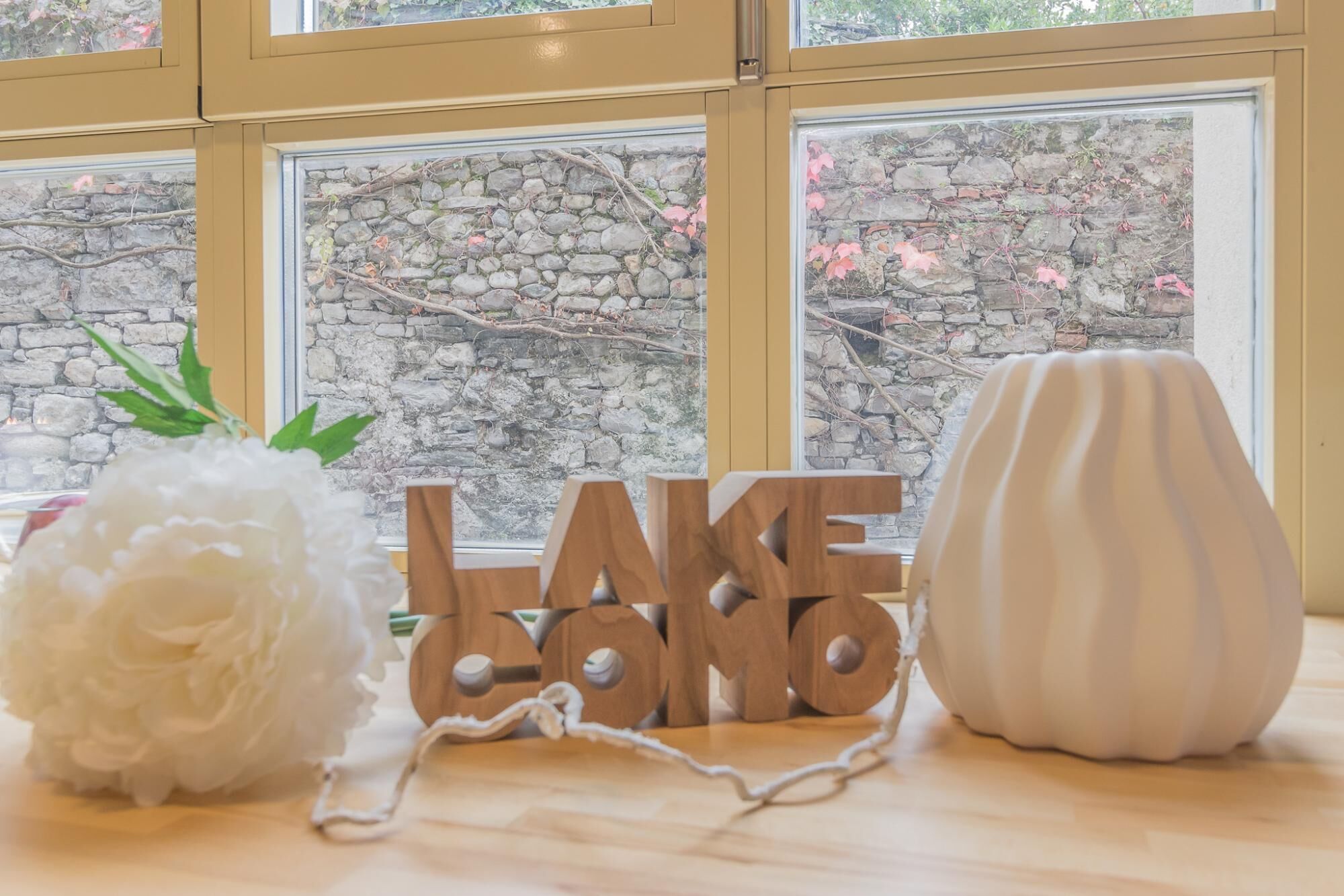 A wooden table with a white vase, a wooden sign reading "LAKE LAGOON", and a white decorative object.