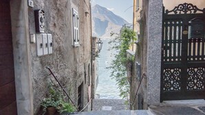Un escalier étroit en pierre mène à un plan d’eau, de part et d’autre duquel se dressent des bâtiments dotés de portails richement décorés et d’une architecture traditionnelle.