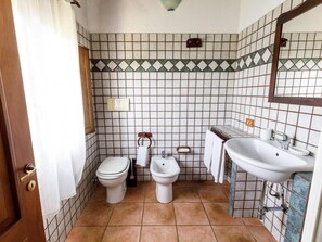 Un baño con dos inodoros, un lavabo y un espejo.