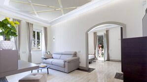 A modern living room with a sofa, coffee table, and a potted plant. - Villa Nina in Sorrento (Sorrento)