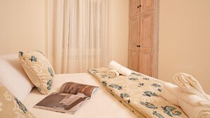 Een keurig opgemaakt bed met bloemenbedrukking, een kussen en een tijdschrift.